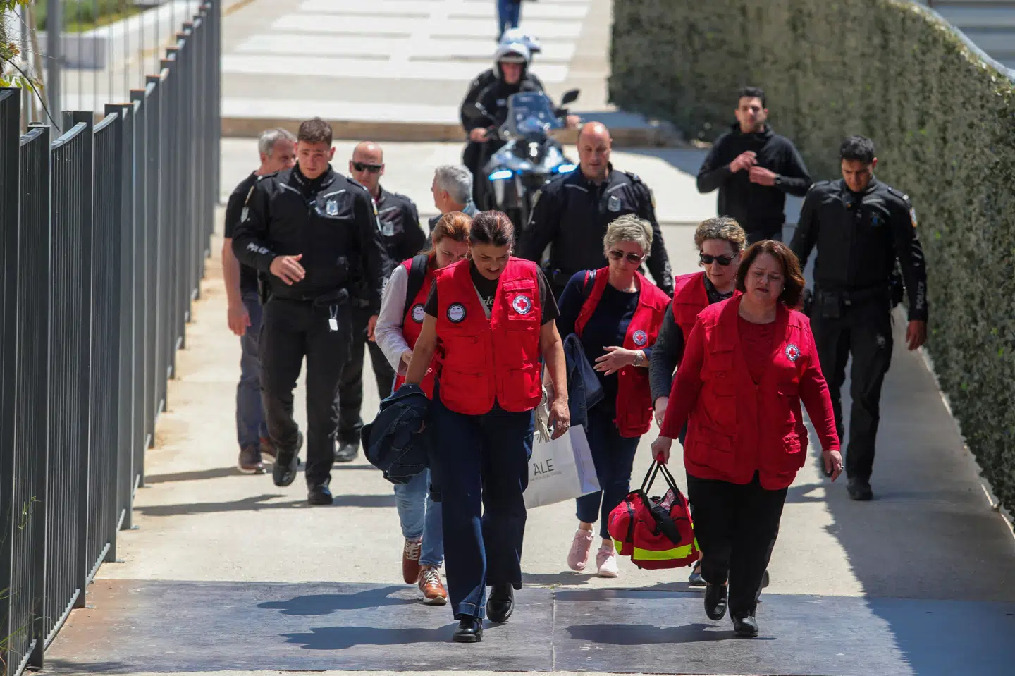 Redningsfolk og politibetjente går uden for en retsbygning i Athen, hvor et skyderi har fundet sted tirsdag.