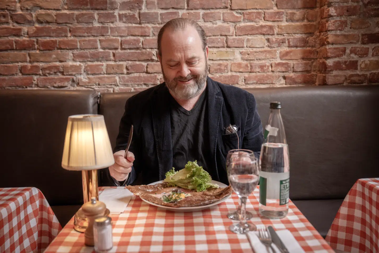 En glad gastronomiredaktør i godt selskab med en helt ukrukket sprød crêpe med ost, skinke og spejlæg.