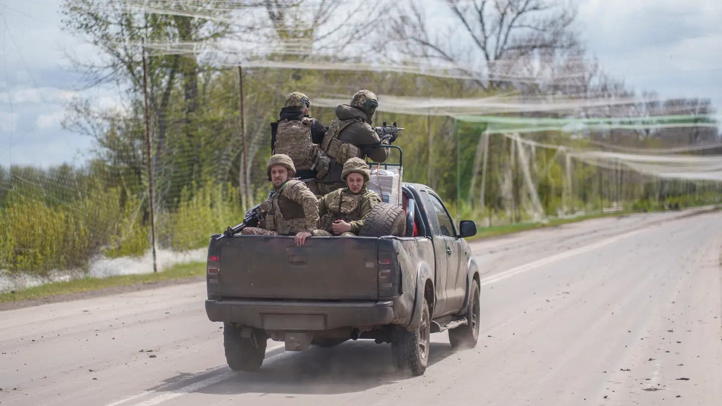 En gruppe ukrainske soldater i en firhjulstrækker beskyttet af net, så de ikke kan blive ramt af en drone.