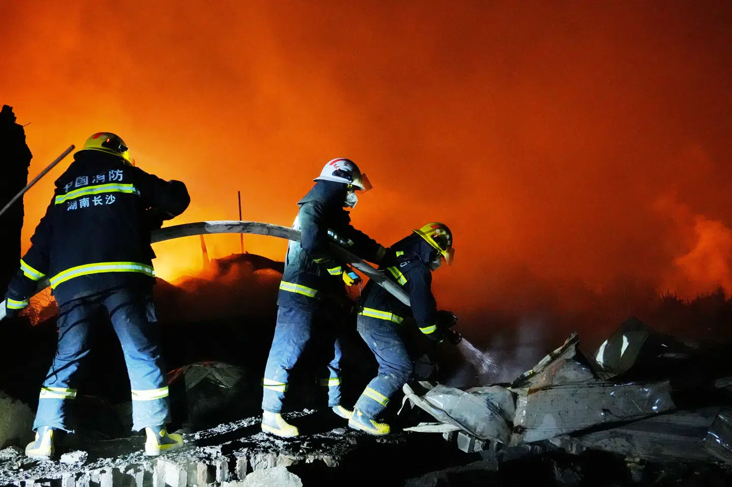 Brandfolk kæmper med slukningsarbejdet efter en brand efter en eksplosion på en fyrværkerifabrik mandag i den kinesiske by Changsha.