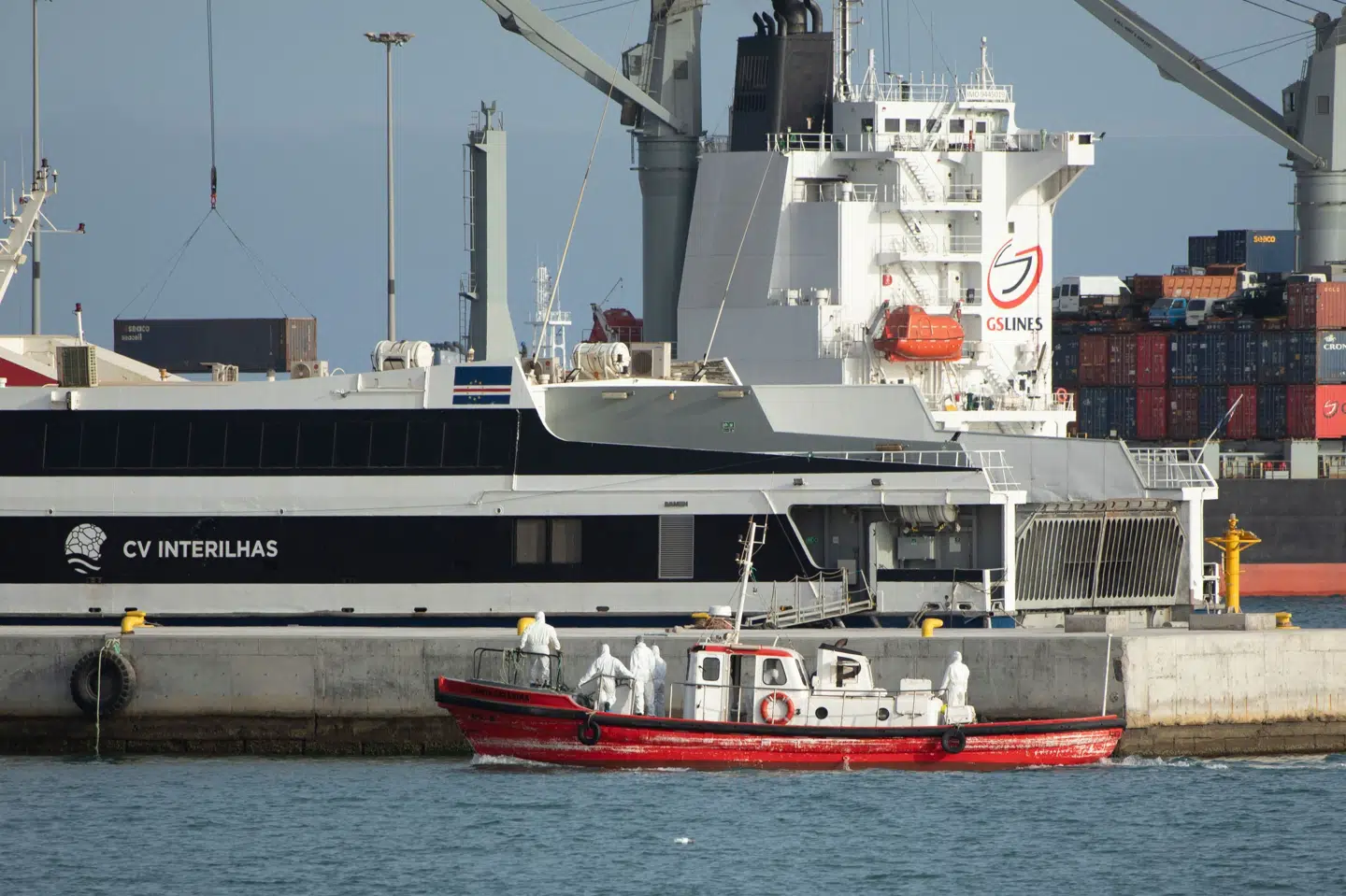 Besætningsmedlemmer på en ambulancebåd iført kemikalieindsatsdragter ankommer til havnen i Praia, efter at de har besøgt et krydstogtskib, hvor der formodes at være sket et udbrud af hantavirus.