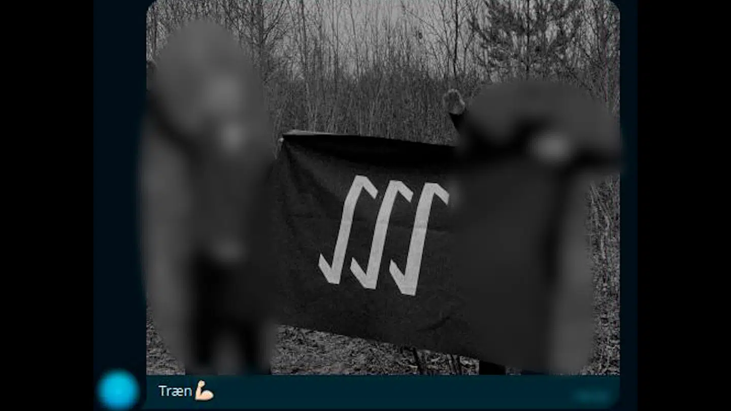 En bruger i den lukkede chat på Telegram har delt dette billede, hvor to personer heiler, mens de holder et banner med The Bases logo. Der er tilsyneladende tale om danske medlemmer af The Base.