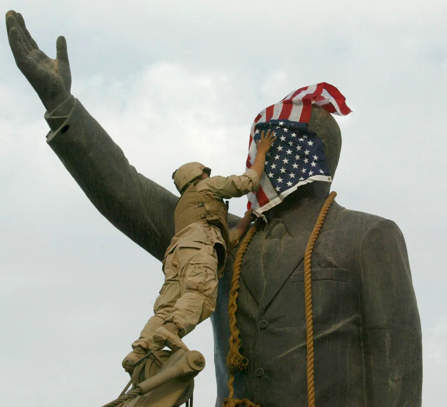 Den amerikanske invasion af Irak i 2003 er blot et kapitel i en lang række af regimeskift, der fik katastrofale konsekvenser for både den invaderende part og civilbefolkningen, mener den amerikanske professor Alexander B. Downes. Alligevel flirter præsident Donald Trump med tanken om et amerikanskledet regimeskifte i Teheran. På billedet tildækker en amerikansk marinesoldat en statue af den irakiske diktator Saddam Hussein i Bagdad 9. april 2003.