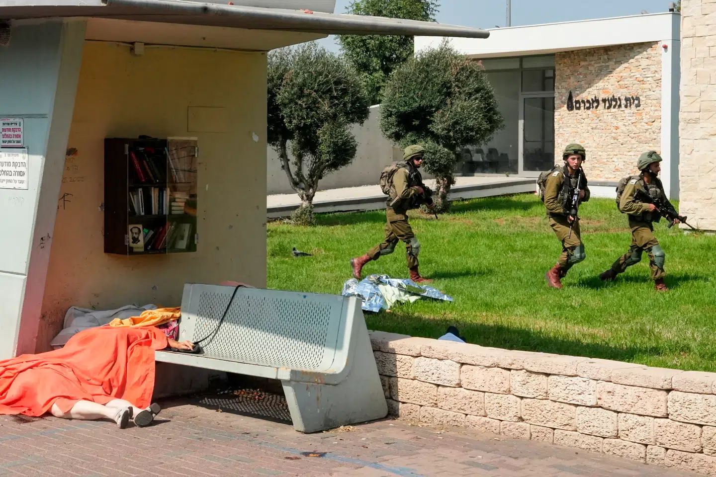 Israelske soldater i færd med at sikre et område i den israelske by Sderot 7. oktober 2023. På jorden ligger civile ofre for Hamas' terrorangreb. Omtrent 1.200 mennesker blev dræbt i angrebene.