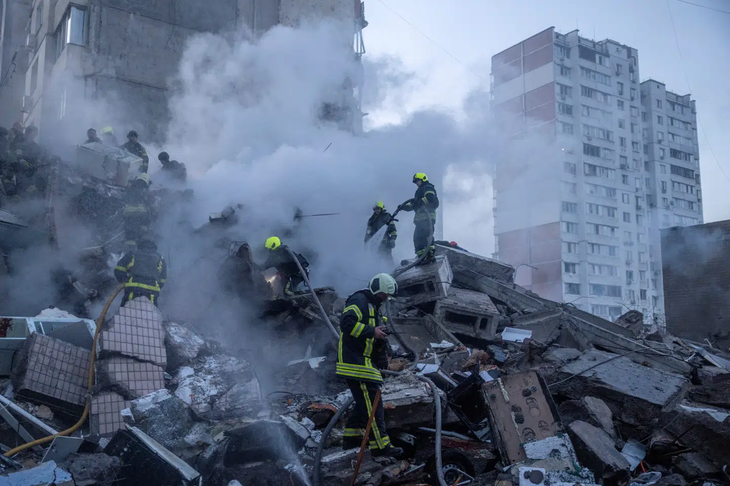 Redningsmandskab ses her arbejde på stedet for en beboelsesbygning, der er blevet delvist ødelagt efter russiske angreb i Kyiv den 14. maj.