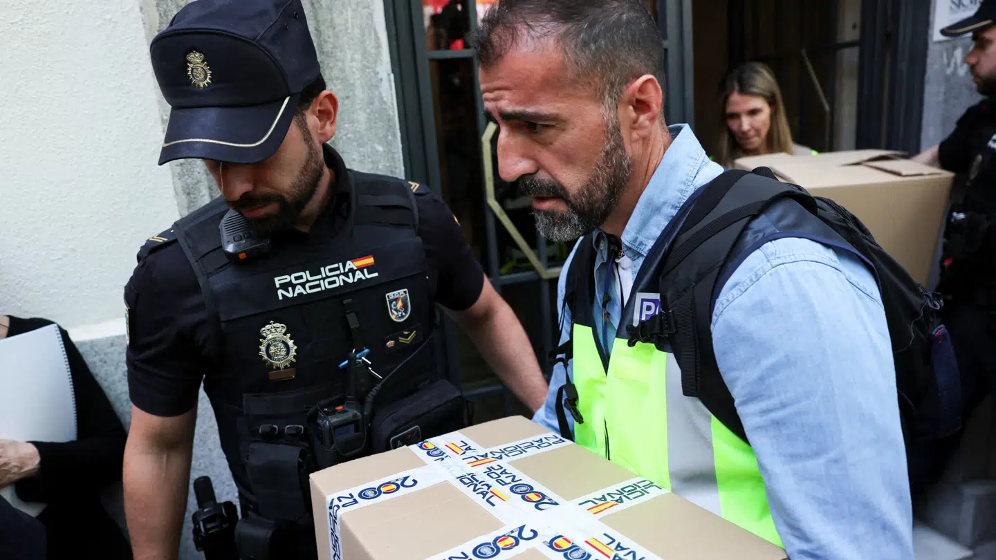 Her ses politiet slæbe kasser med dokumenter ud under ransagningen af ekspremierministerens hjem.