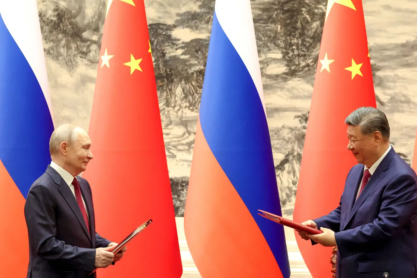 Ruslands og Kinas statsledere udveksler dokumenter under underskriftsceremoni i Beijing.