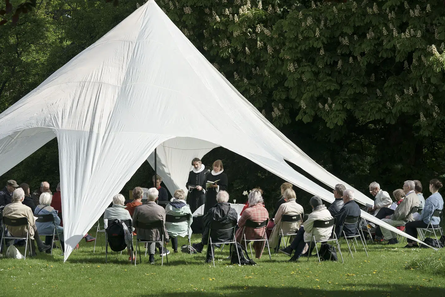 Billedet er fra 2. pinsedag i 2021 og viser en friluftsgudstjeneste i Frederiksborg Slotshave. Mandag vil byde på 18-23 grader og plads til sol, siger meteorolog. (Arkivfoto).
