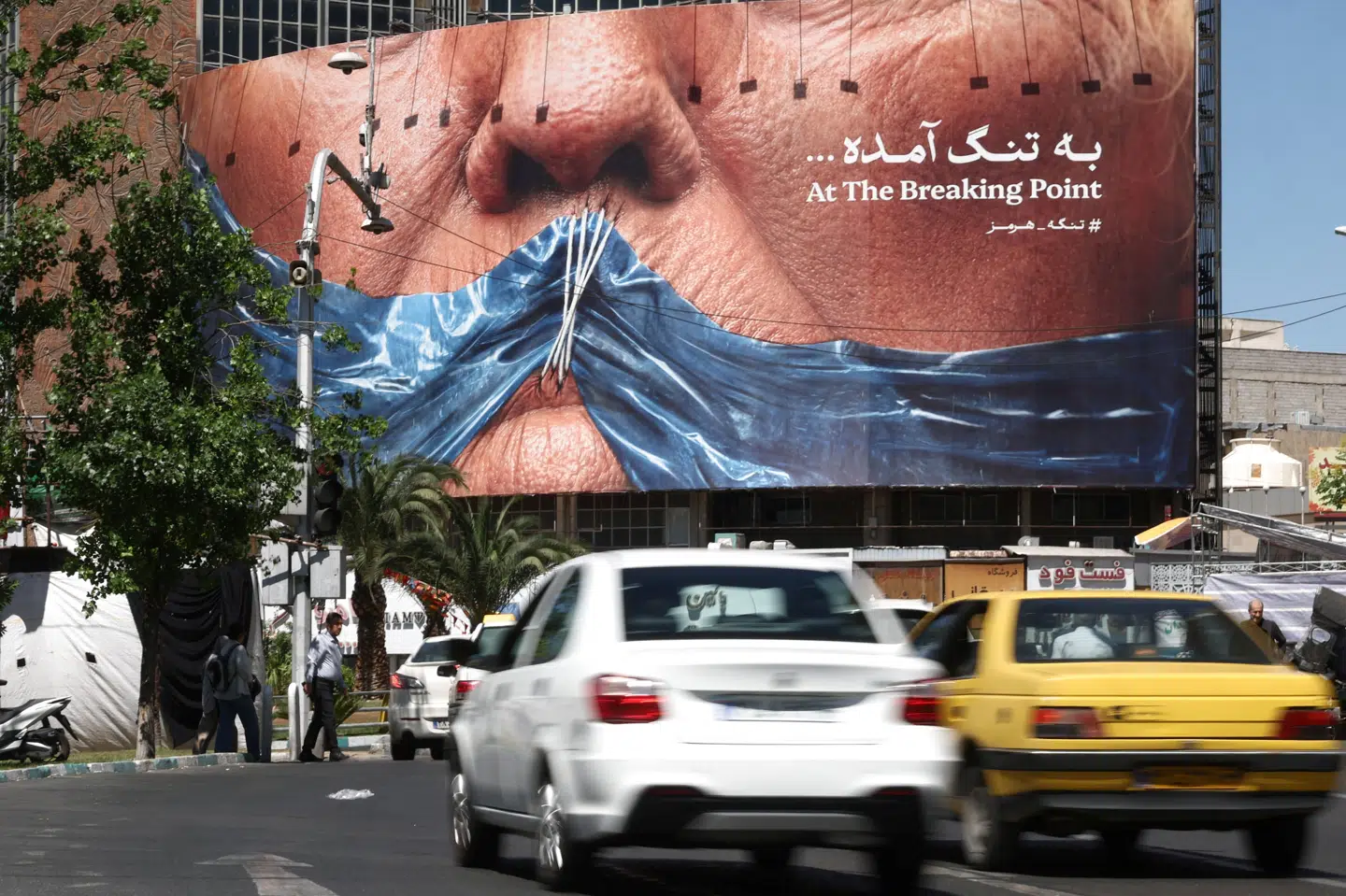 Folk kører forbi antiamerikanske plakattavler i Irans hovedstad, Teheran, tirsdag, hvor der er usikkerhed om den diplomatiske udvikling.