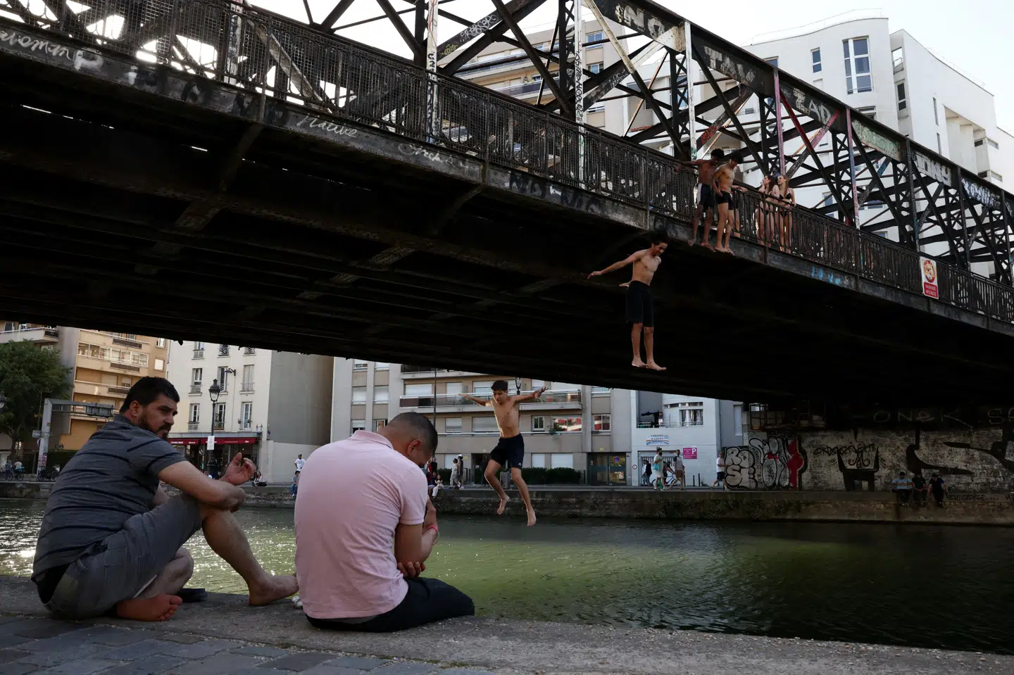 Unge springer i kanalen i Paris under varmebølge i Frankrig.