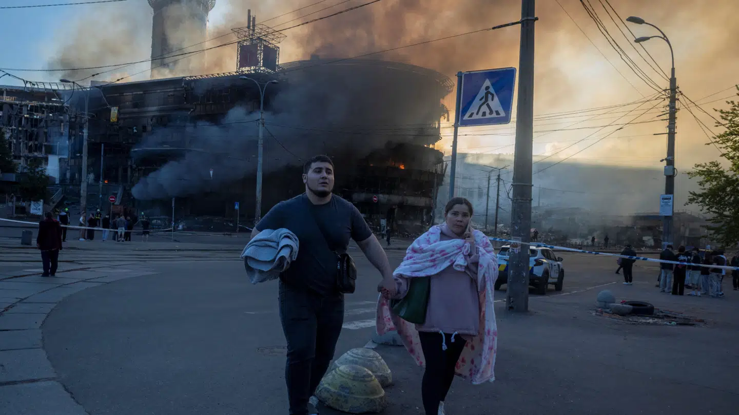 Folk flygter fra en bygning i flammer, efter den var blevet ramt af et af de mange russiske angreb på Kyiv 24. maj 2026.
