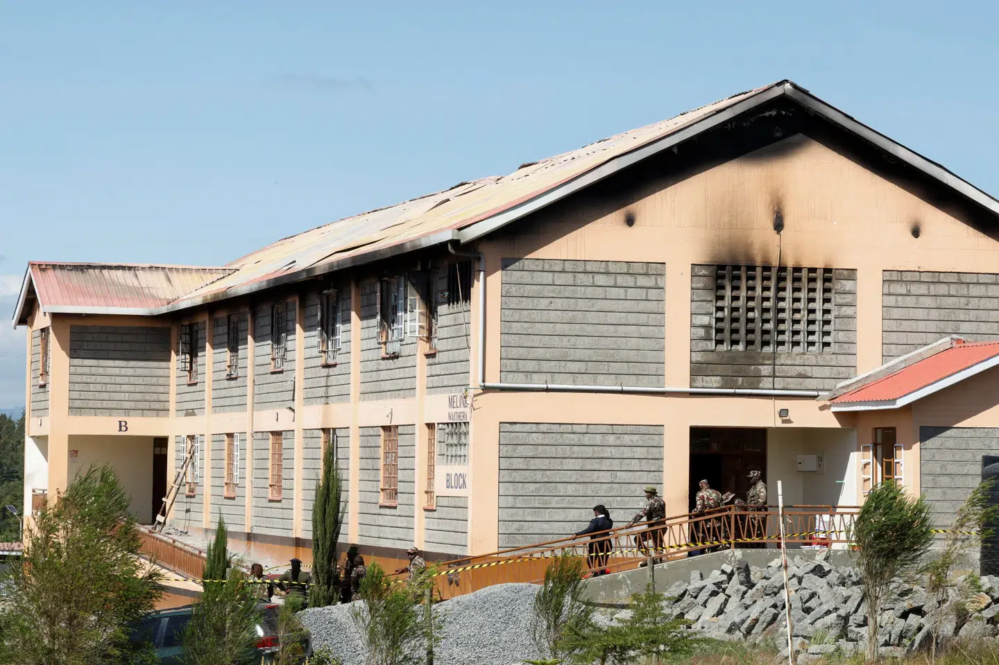Sikkerhedsvagter står uden for sovesalen på en pigeskole i Kenya, hvor en brand brød ud natten til torsdag.