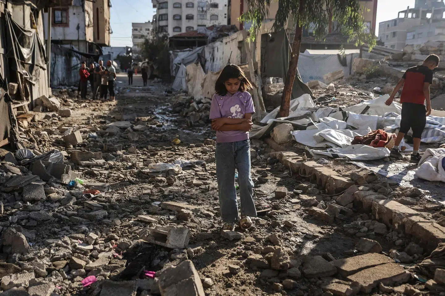 En palæstinensisk pige går gennem ruinerne af huse og telte i Gaza By, der natten til torsdag blev udsat for et israelsk luftangreb. Mindst ti mennesker blev dræbt. Nu siger Israels premierminister, Benjamin Netanyahu, at Israel vil tage kontrol med en endnu større del af Gazastriben og presse Gazastribens omkring to millioner fordrevne indbyggere endnu tættere sammen.