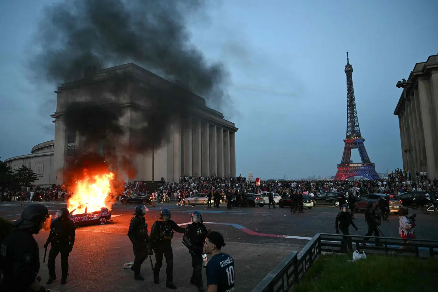 En bil brænder i Paris lørdag aften, efter at fodboldfans fejrer Champions League-sejren over Arsenal. Politiet har foretaget over 130 anholdelser og brugt tåregas.