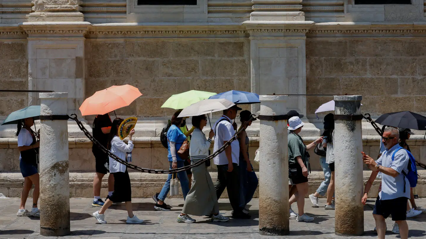 Turister forsøger at undgå solen i Sevilla.