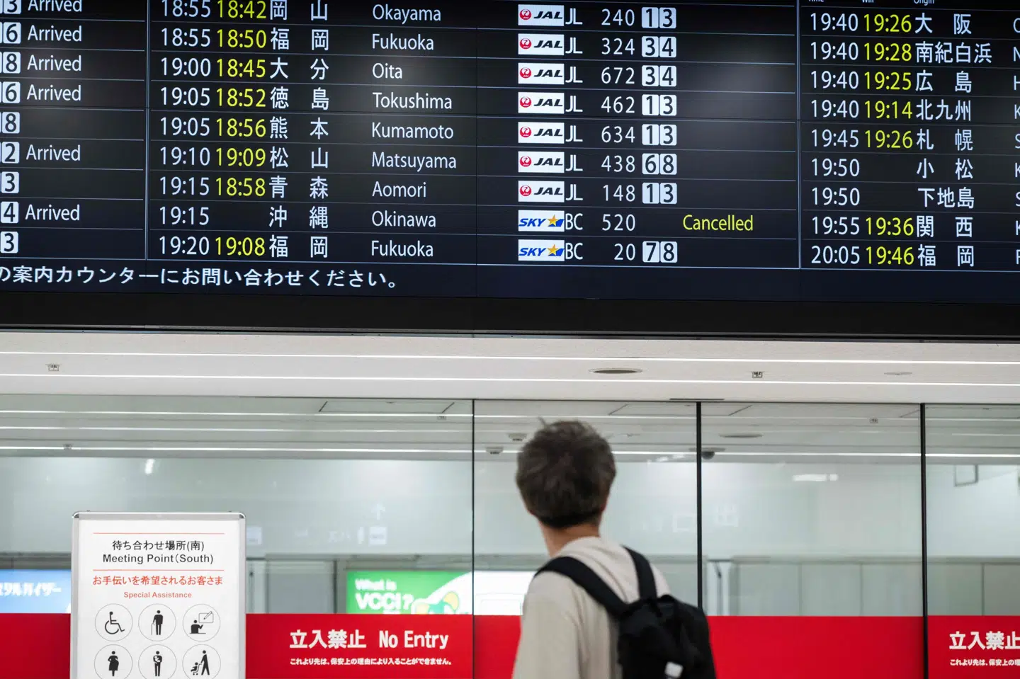 Billede fra mandag viser mand, der betragter skærm med flyafgange i Tokyo, hvor der kan ses aflysning som følge af stormen Jangmi. (Arkivfoto).