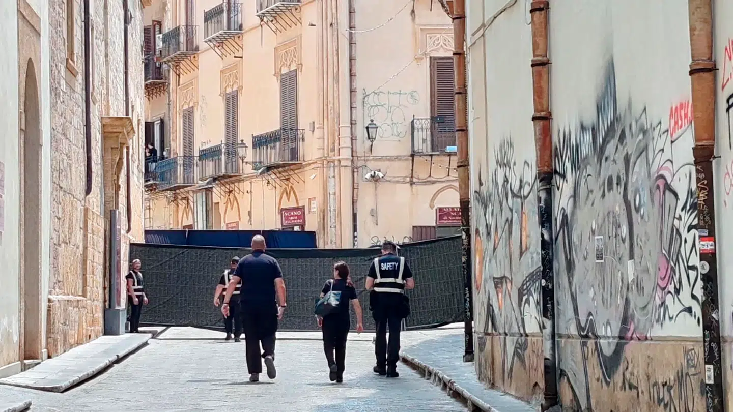 Sikkerhedsfolk foran afspærringen i Palermos gader forud for festlighederne. Det er særligt disse afspærringer, som frustrerer de lokale indbyggere.