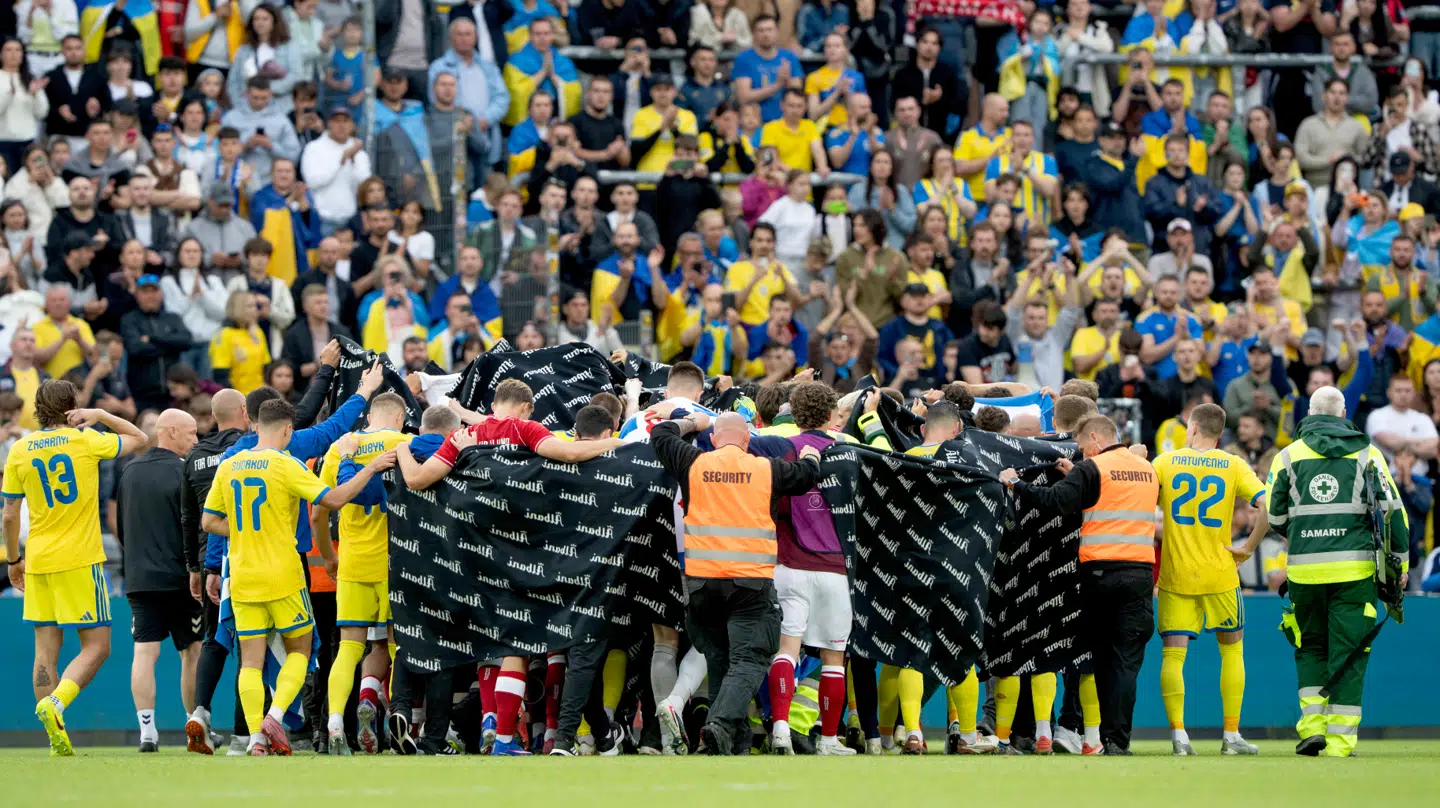 Spillerne slog ring om Christian Eriksen og fulgte ham ud til en ambulance på stadion i Odense.