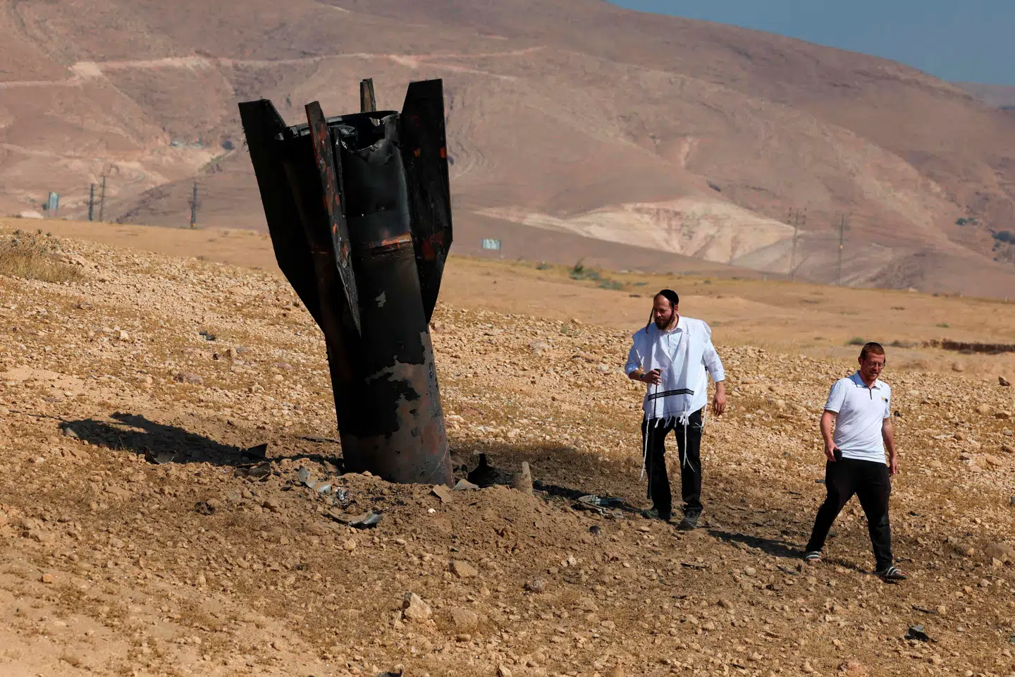 Som en kile mellem allierede. Israelske mænd inspicerer resterne af en iransk raket.