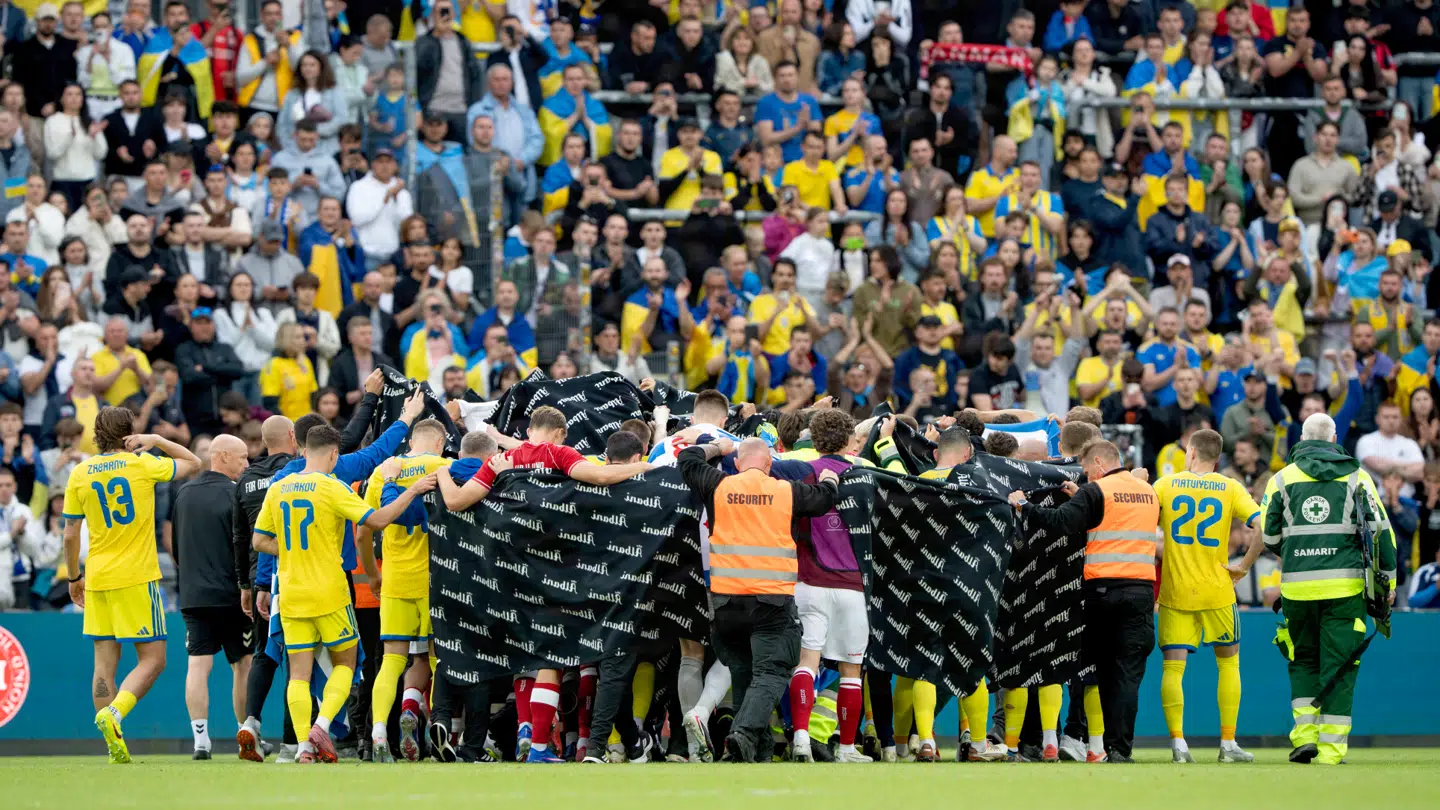 Både danske og ukrainske spillere stod side om side, efter søndagens landskamp blev afbrudt.