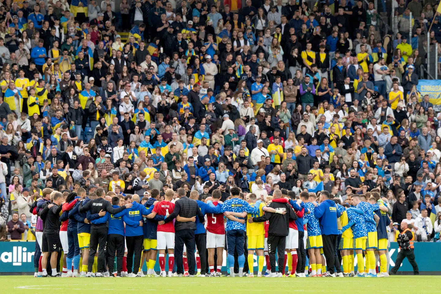 Danmarks og Ukraines spillere samler sig efter Christian Eriksen er blevet kørt afsted i en ambulance efter fodboldlandskampen mellem Danmark og Ukraine på Odense Stadion søndag den 7. juni.