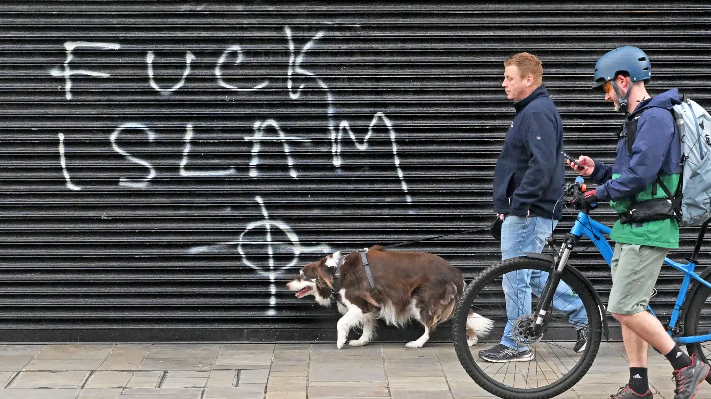 Graffiti i Belfast dagen efter et drabsforsøg på en tilfældig mand på gaden begået af en sudanesisk mand.