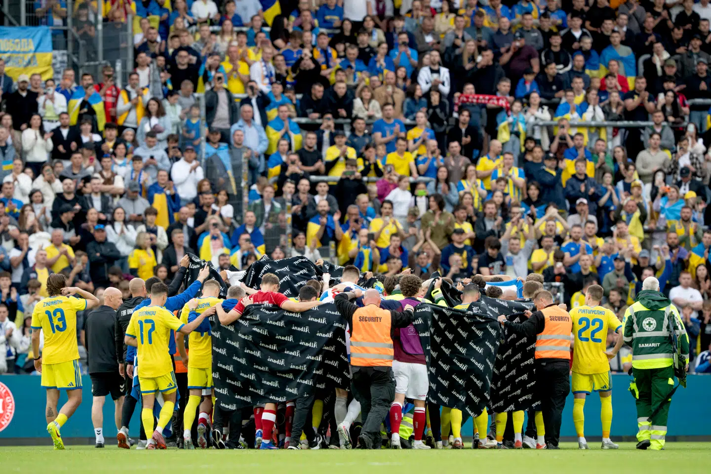 Danmarks og Ukraines spillere følger Christian Eriksen ud til en ventende ambulance under fodboldlandskampen mellem Danmark og Ukraine på Odense Stadion søndag den 7. juni.