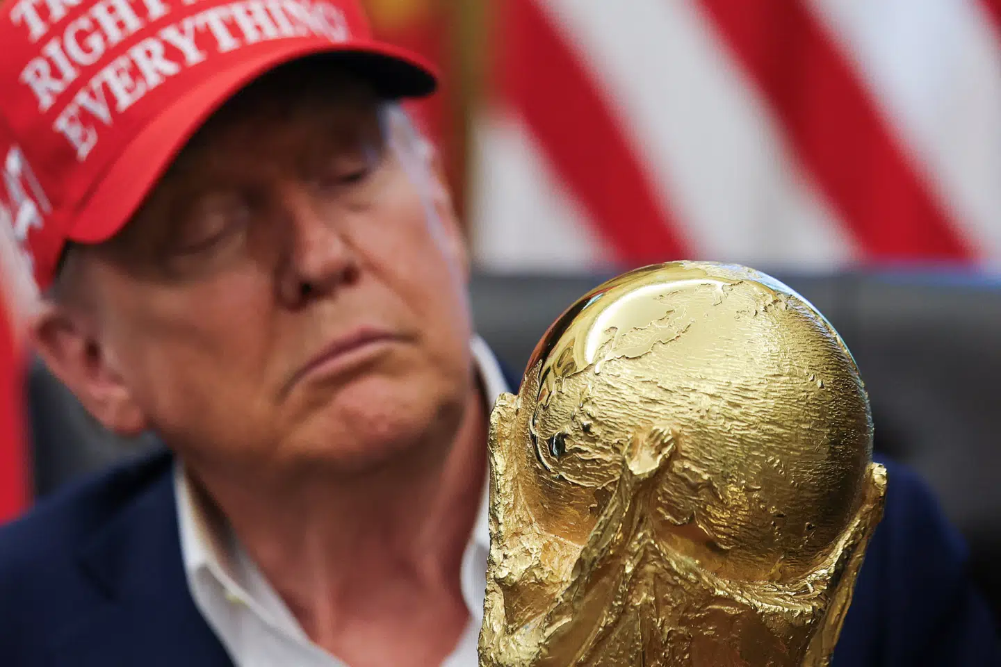 Donald Trump ser på én gang køligt og kærligt på FIFAs gyldne vindertrofæ under en ceremoni forud for sommeren VM-turnering i blandt andet USA.