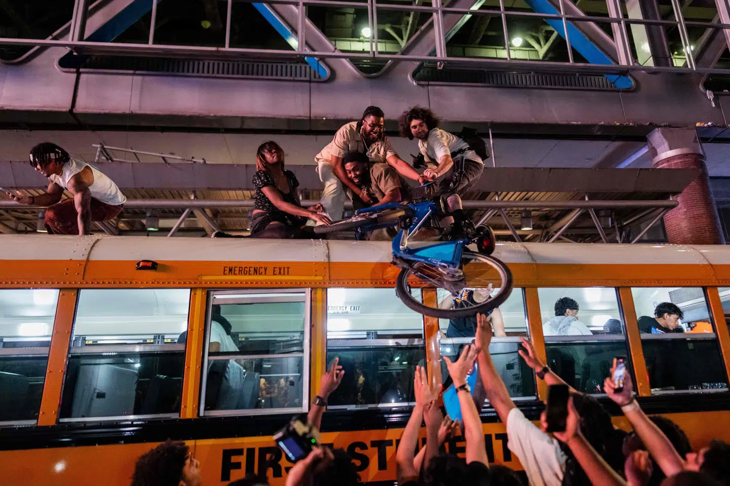 New York Knicks-fans løfter en cykel op på en bus i fejringen af basketballholdets NBA-titel.