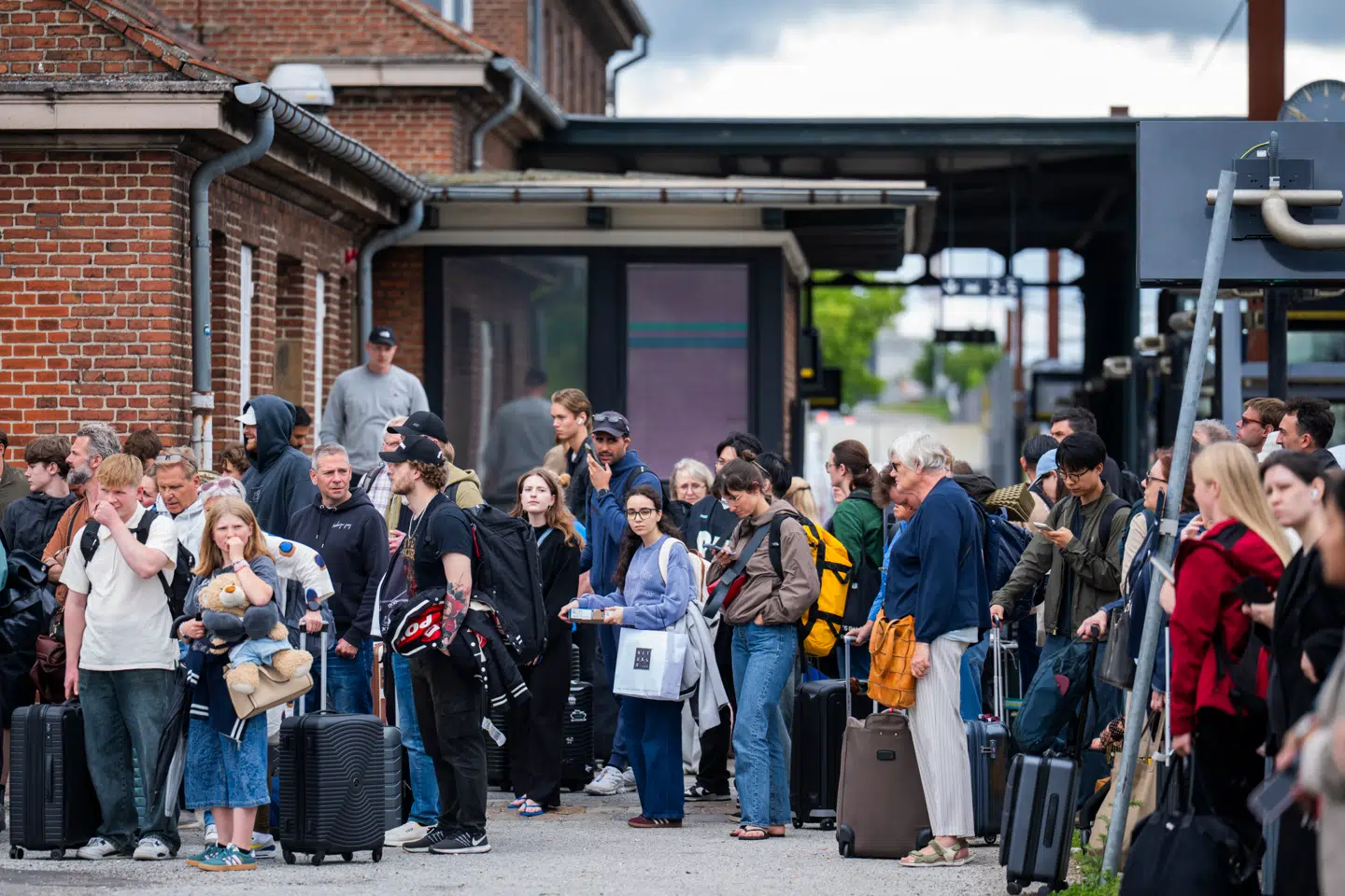 »I stedet for at forsøge at redde sundhedsvæsnet med reelle forbedringer, skal man bare se på DSBs løsninger,« skriver Sebastian Kjærgaard Hendel. Her venter passagerer på togbusser 7. juni 2026, efter en nedreven køreledning bremser tog mellem landsdelene. Foto: Martin Sylvest/Ritzau Scanpix