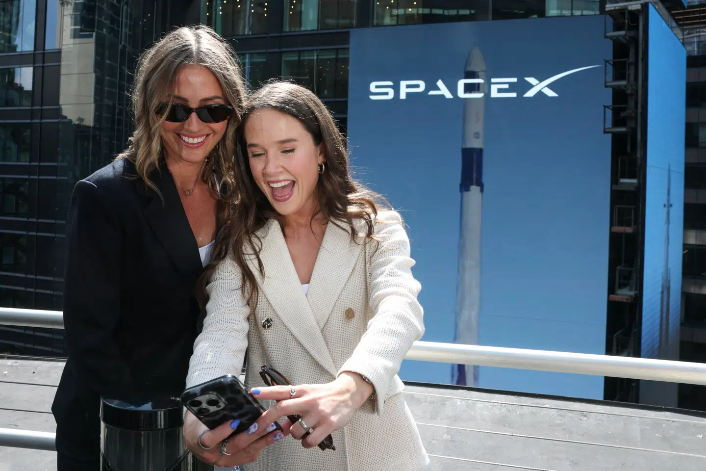 People celebrate on a balcony at the Nasdaq MarketSite on the day of SpaceX's initial public offering (IPO), in New York City, U.S., June 12, 2026. REUTERS/Brendan McDermid