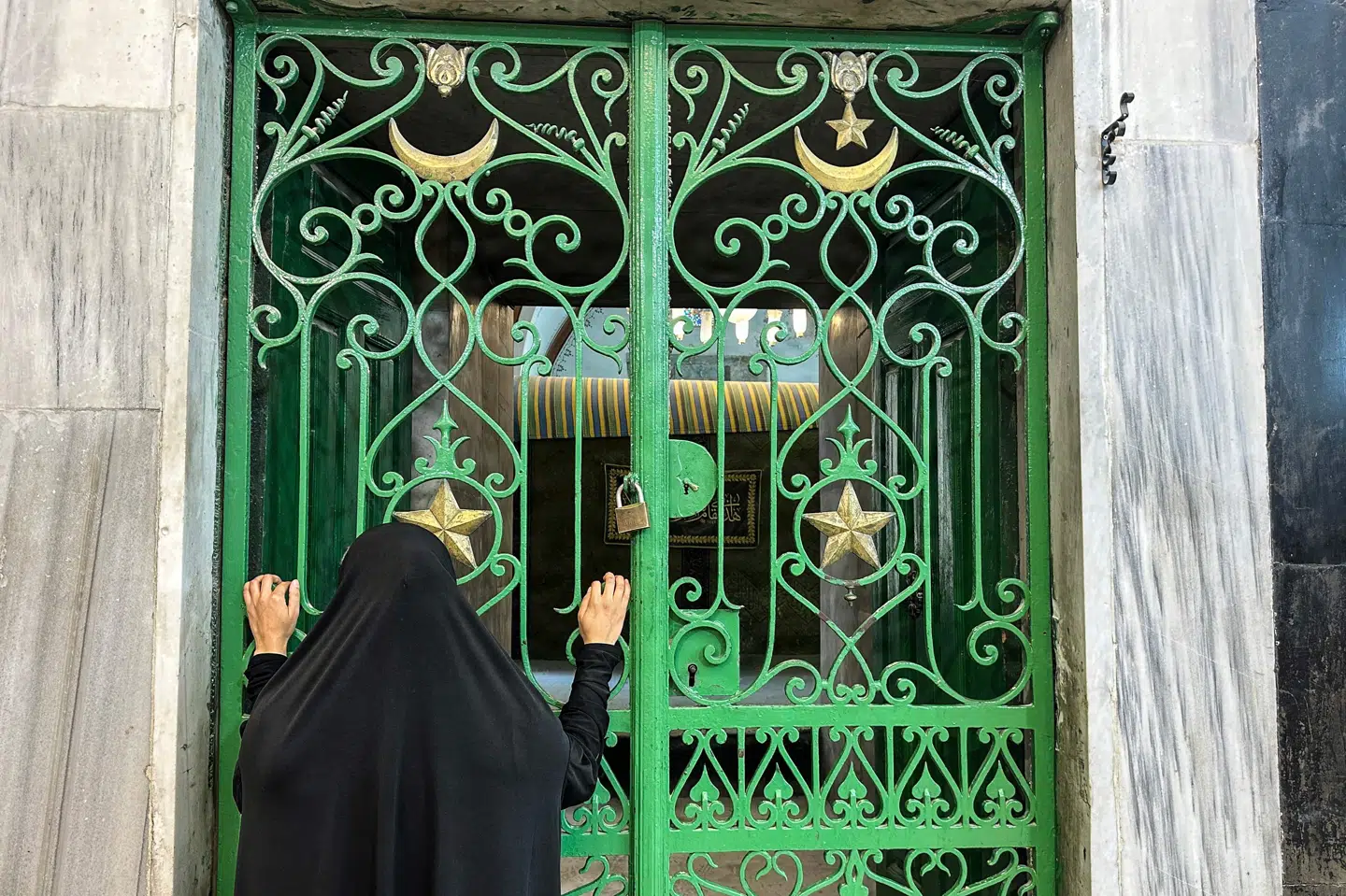 En kvinde kigger ind gennem en port ved Patriarkernes Grav i Hebron, hvor Israel har taget kontrollen.