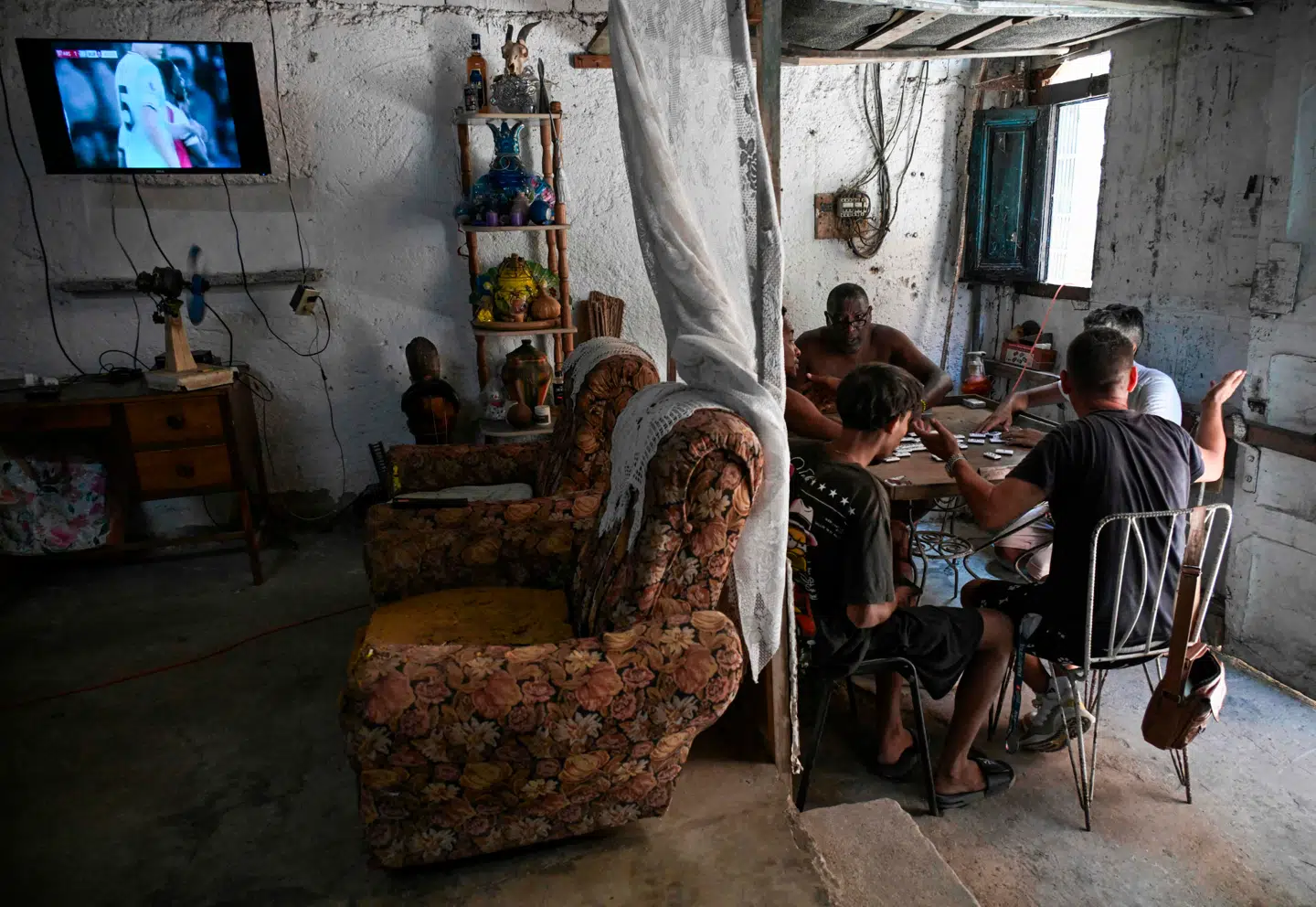 Den økonomiske nedtur har mærket det cubanske samfund i årevis. Her er vi i et cubansk hjem i Havana, hvor lokale hygger sig med et spil domino.