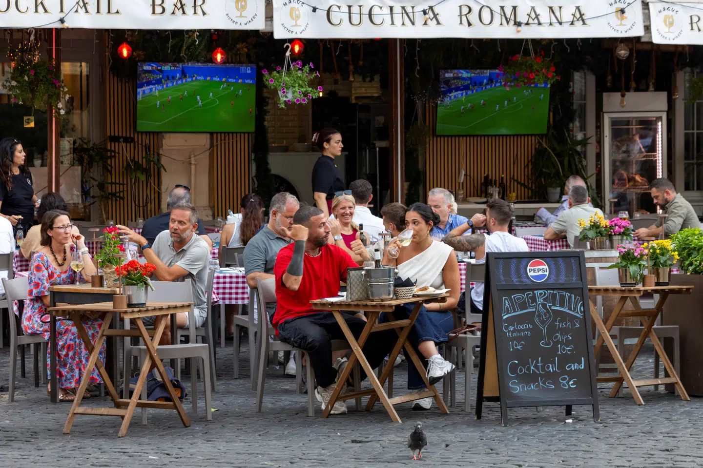 Restaurantgæster nyder et køligt glas hvidvin i Rom, mens de forsøger at ignorere tv-transmissionen fra endnu et VM uden det italienske landshold blandt deltagerne.