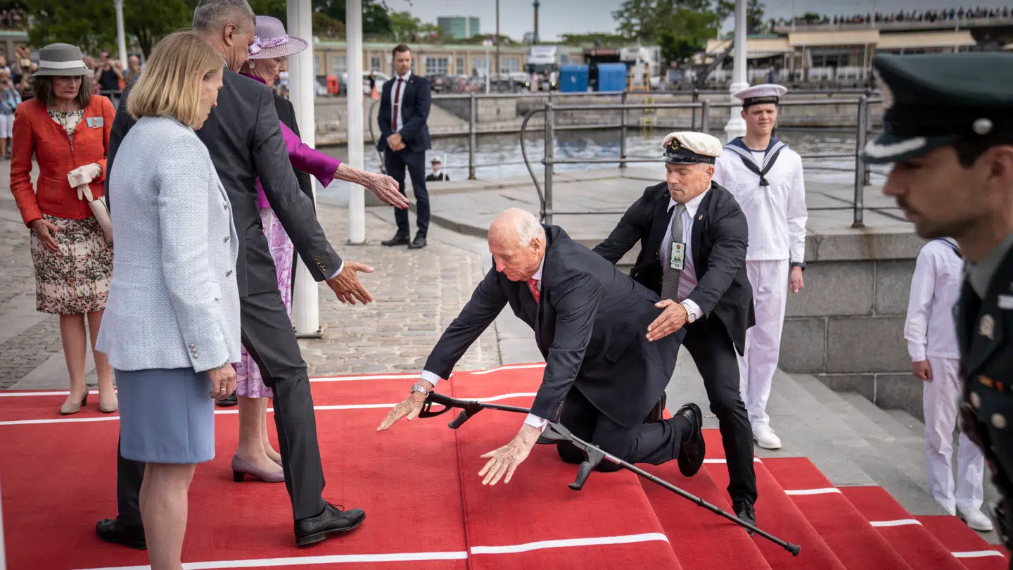 Bentøjet har længe drillet den norske konge. Her snubler han op ad trappen, da han skal hilse på dronning Margrethe under statsbesøget i juni 2023.
