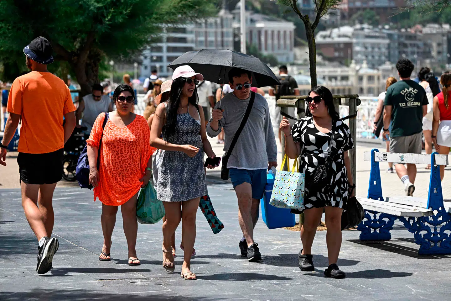 Folk ses her skærme sig mod solen langs stranden La Concha i San Sebastián den 21. juni.