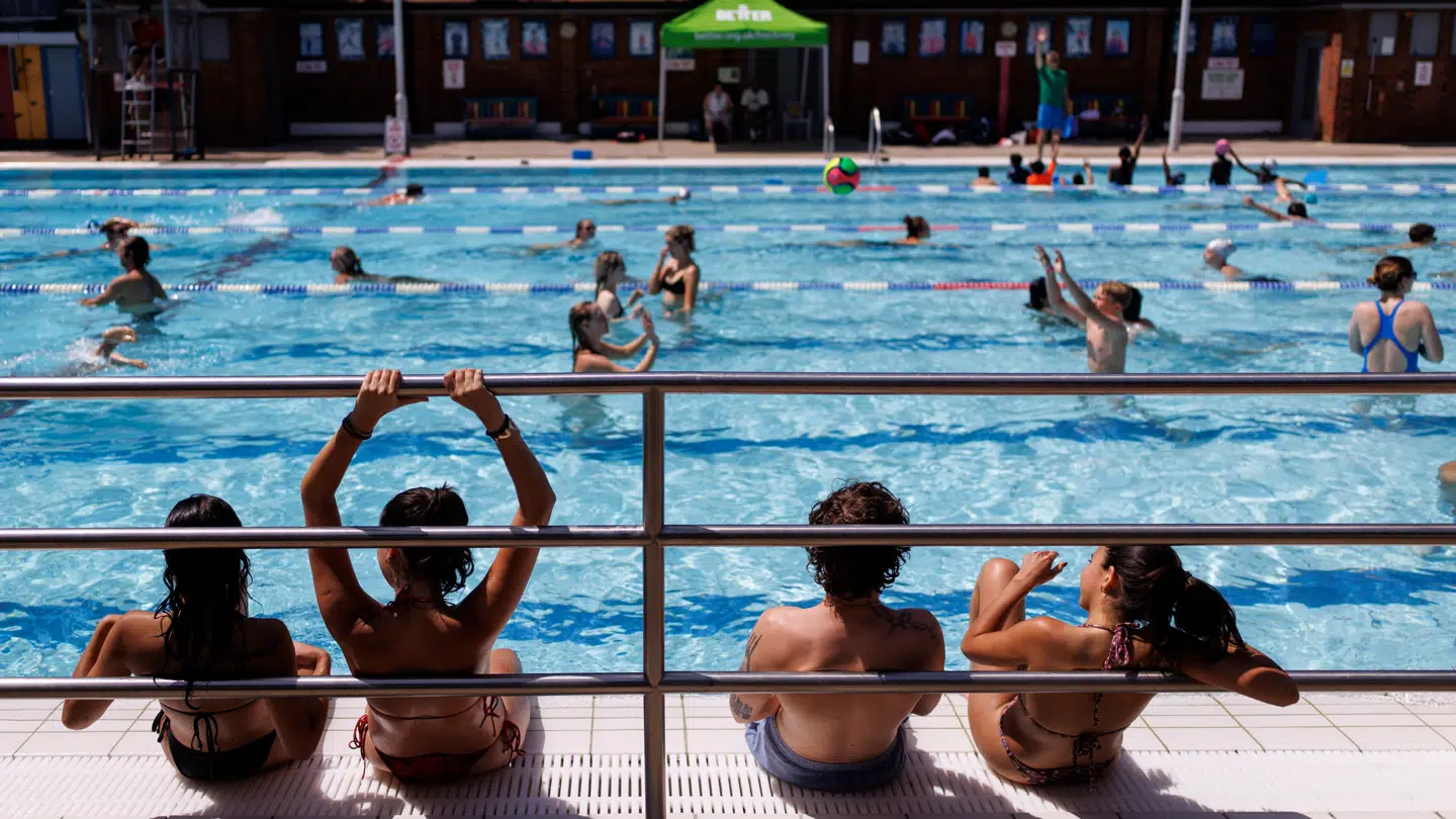 Her ses folk køle sig ned i en udendørs pool i London den 23. juni.