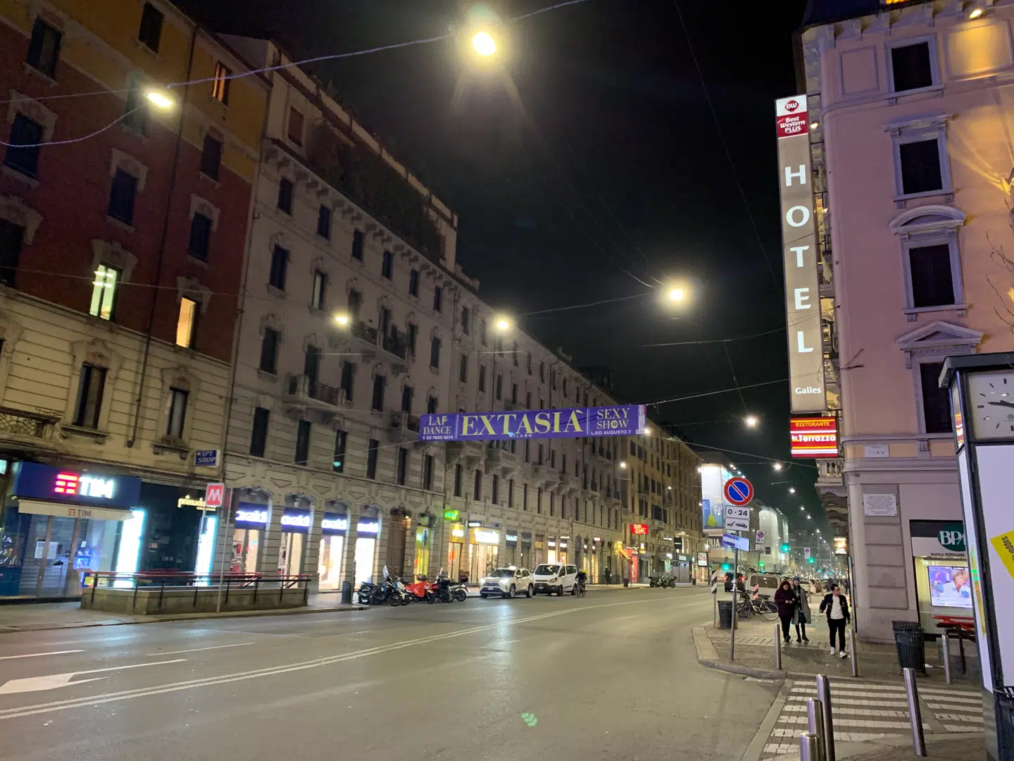 Få gående, biler og cyklister finder vej, men ellers er Milanos livligste shoppinggade mandag aften ret tom.