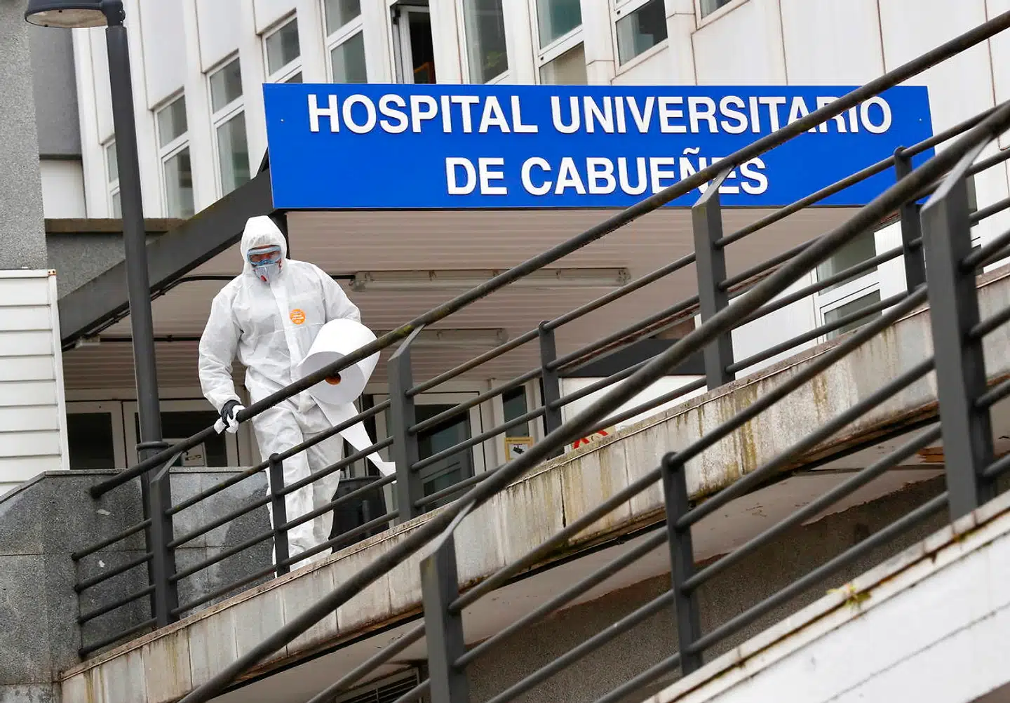 Militæret er blevet sat ind i kampen mod coronavirus, og en soldat er her i gang med at rense området udenfor et nordspansk hospital iført sikkerhedsudstyr. Ikke alle, der er i kontakt med smitten, er lige så veludrustede.