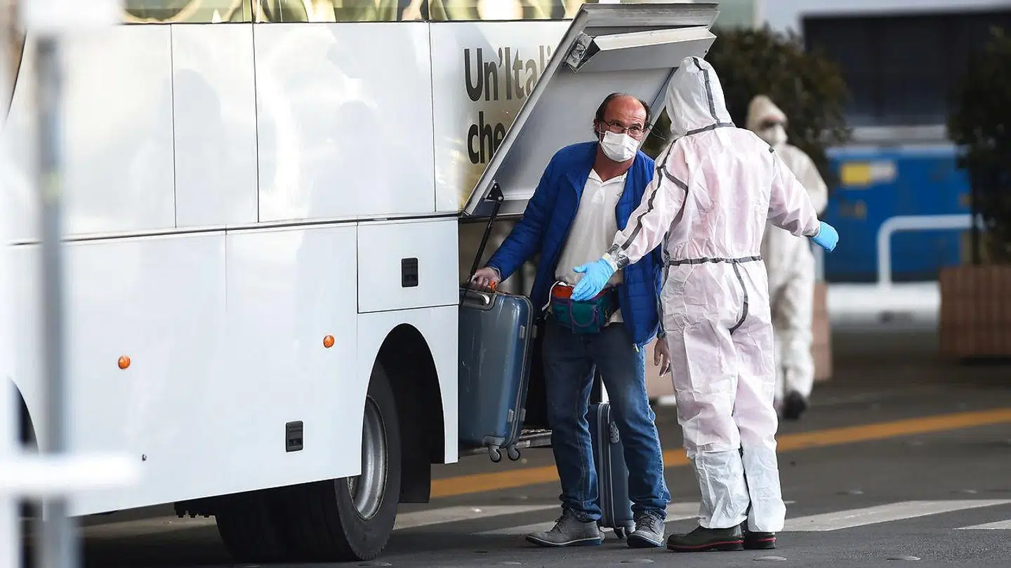 En passager fra krydstogtsskibet Costa Luminosa kommer på en bus efter evakueringen i den italienske havneby Savona.
