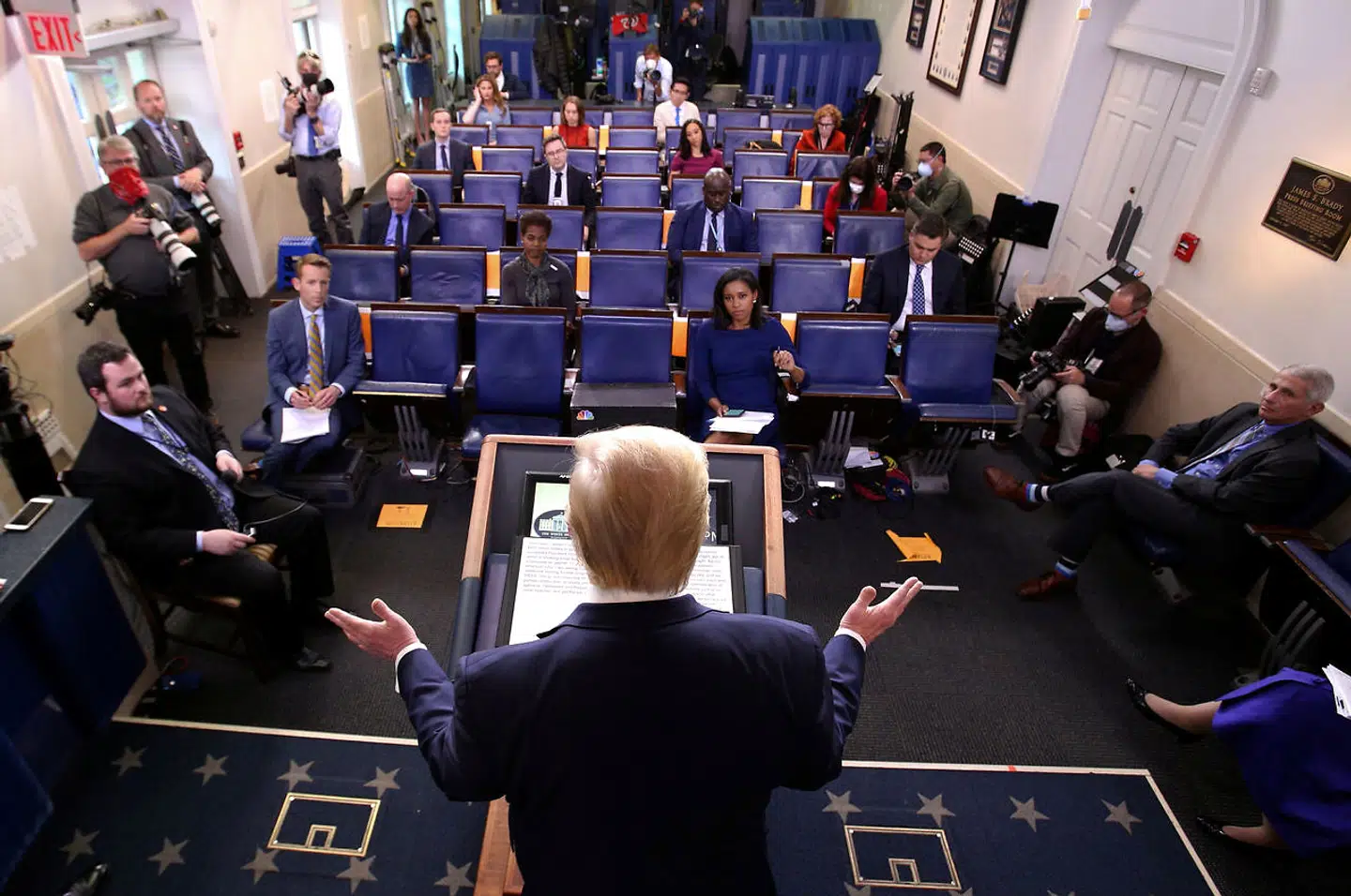 Mens Donald Trump taler, sidder de inviterede journalister med fornuftig afstand.