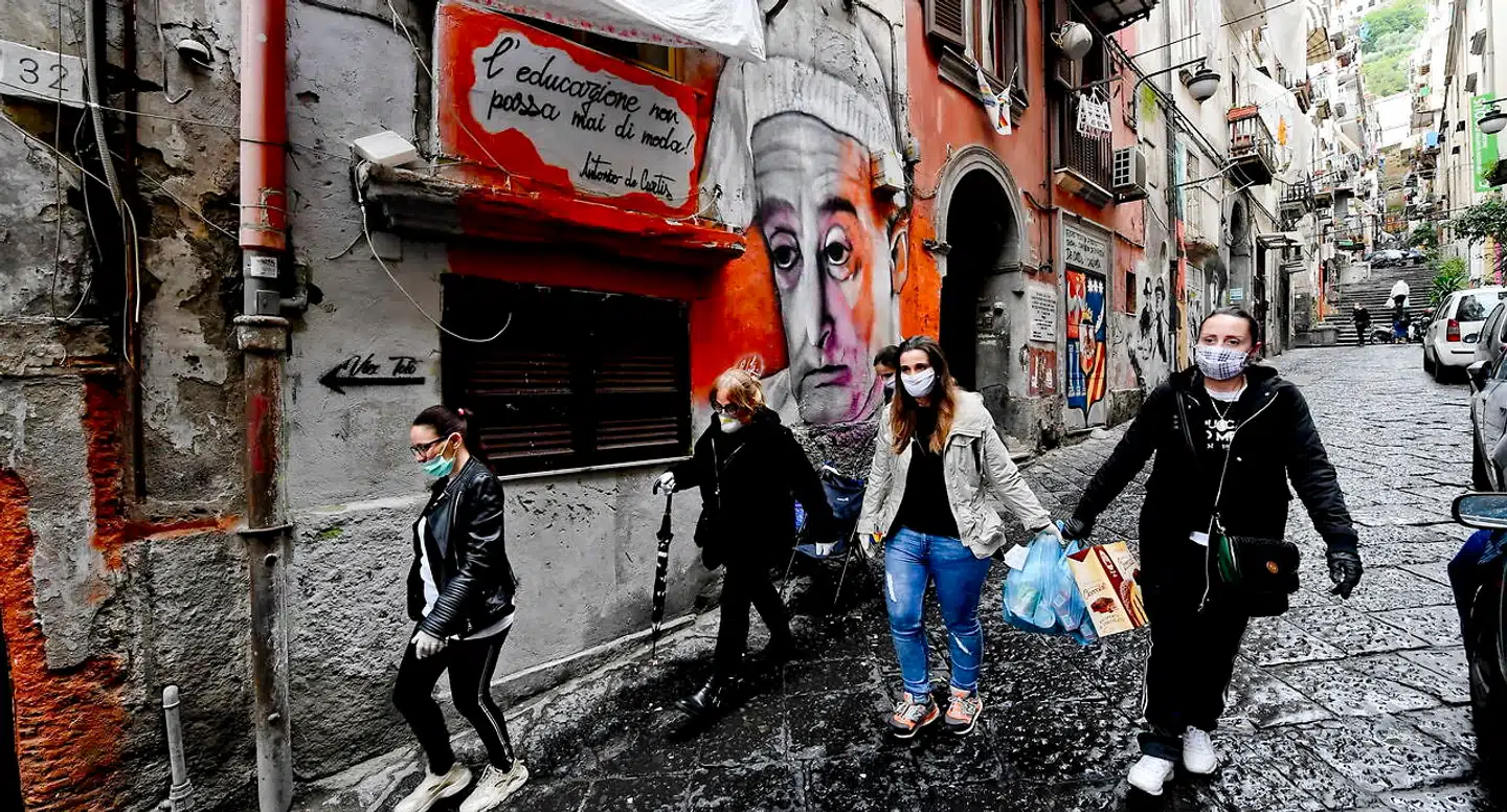 Frivillige i færd med at uddele fødevarer og bøger blandt epidemiens økonomiske ofre i Napolis centrale og ludfattige Quartieri Spagnoli. Der har været flere eksempler på, at de får konkurrence fra den lokale mafia, La Camorra, hvis velgørenhed på ingen måde er uegennyttig.