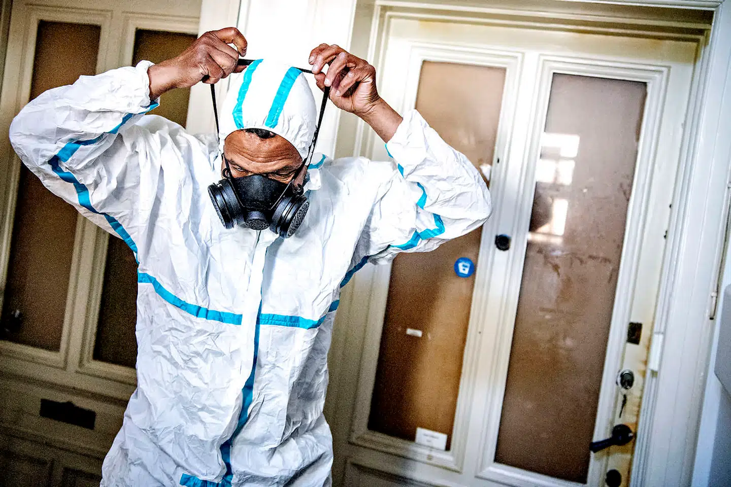 Det kræver både beskyttelsesdragt, åndedrætsværn og handsker, for at rengøringsfirmaet går ind i lejligheden.