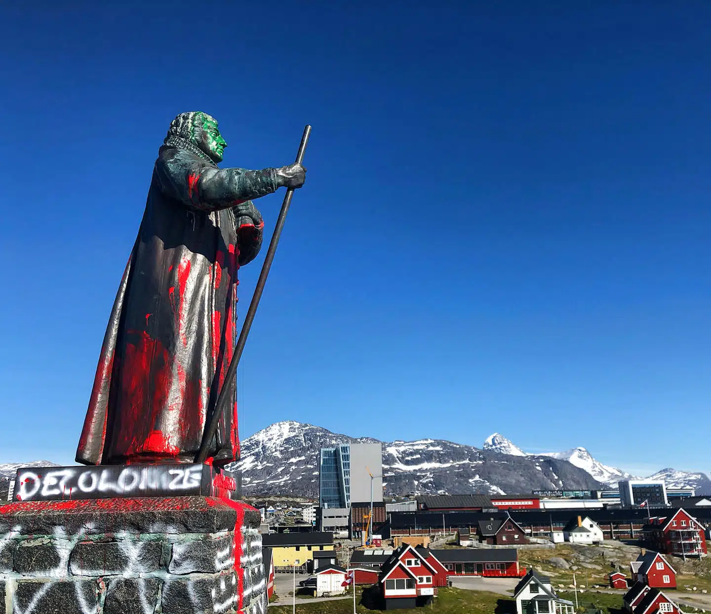 Hans Egede-statuen i Nuuk, Grønland. »Decolonize (dekolonisér, red.),« står der skrevet på siden.