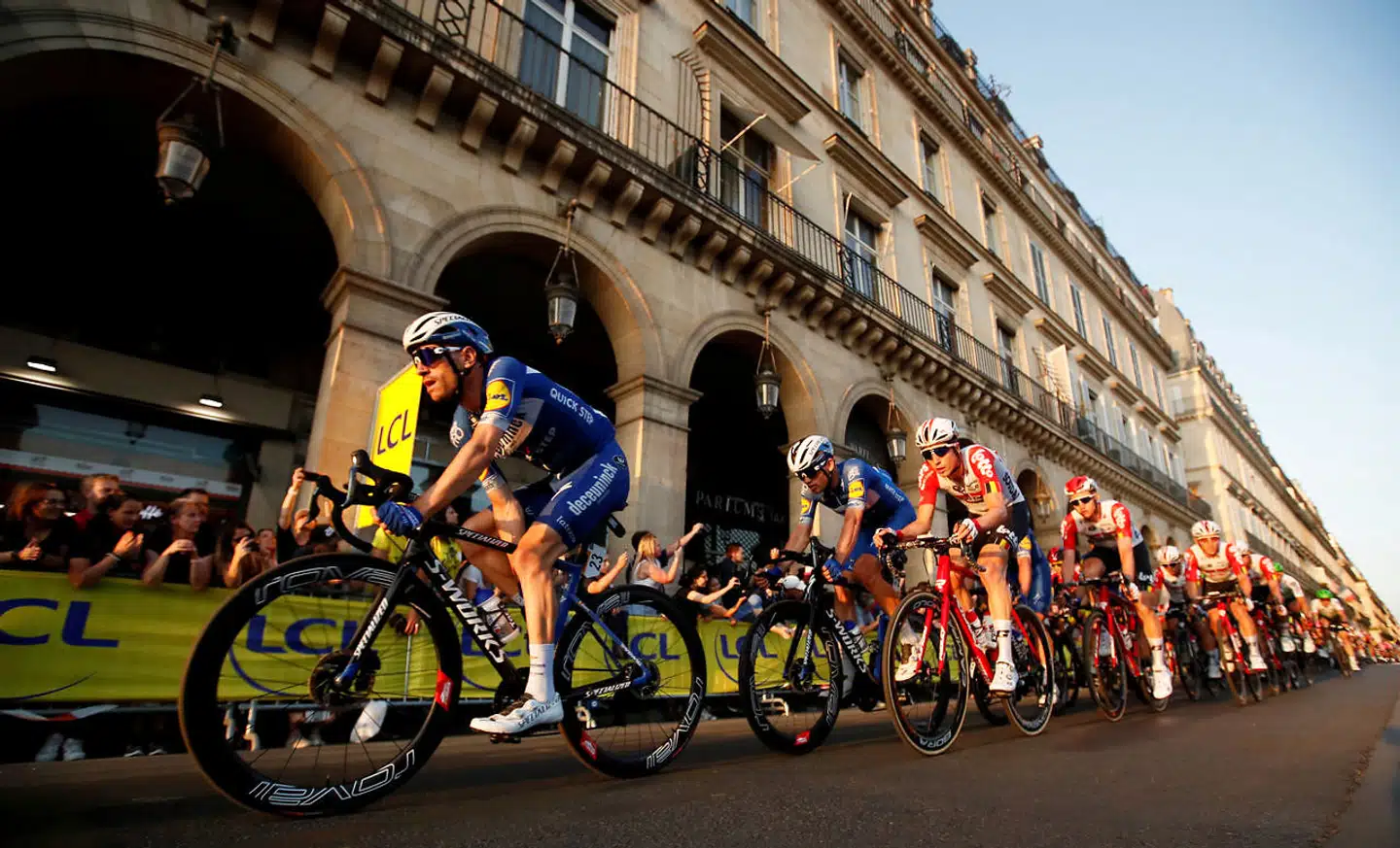 FILE PHOTO: Cycling - Tour de France - The 128-km Stage 21 from Rambouillet to Paris Champs-Elysees - July 28, 2019 - Deceuninck-Quick Step riders Dries Devenyns of Belgium and Kasper Asgreen of Denmark and Lotto Soudal rider Jens Keukeleire of Belgium in the peloton. REUTERS/Gonzalo Fuentes/File Photo