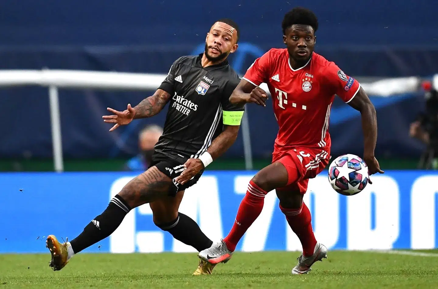 Lyon's Dutch forward Memphis Depay (L) challenges Bayern Munich's Canadian midfielder Alphonso Davies during the UEFA Champions League semi-final football match between Lyon and Bayern Munich at the Jose Alvalade stadium in Lisbon on August 19, 2020. (Photo by FRANCK FIFE / POOL / AFP)