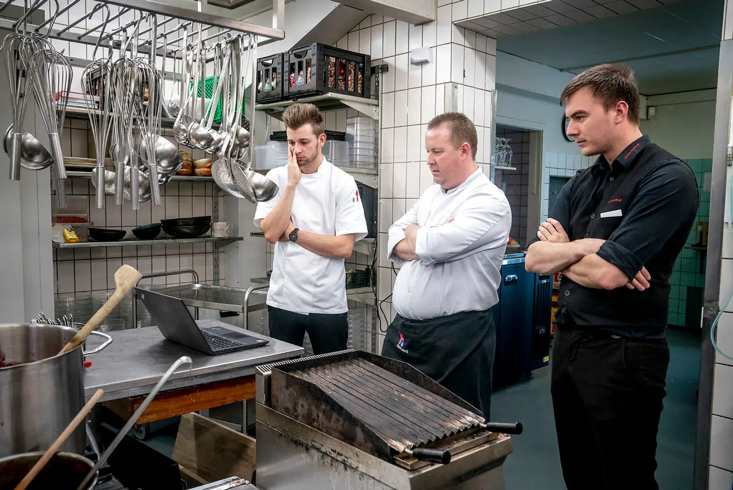 Hotelchef Simon Reiche (tv), Ronni og Thomas (th) står i køkkenet på Hjallerup Kro i Nordjylland, mens de ser til Statsministerens pressemøde. "Vi har jo ikke noget valg og jeg kan da godt se, at det giver mening, så vi må holde lukket fra i morgen. Det er godt, at vi er hårdføre i Nordjylland, " konstaterer Simon, da nyheden er sunket ind.