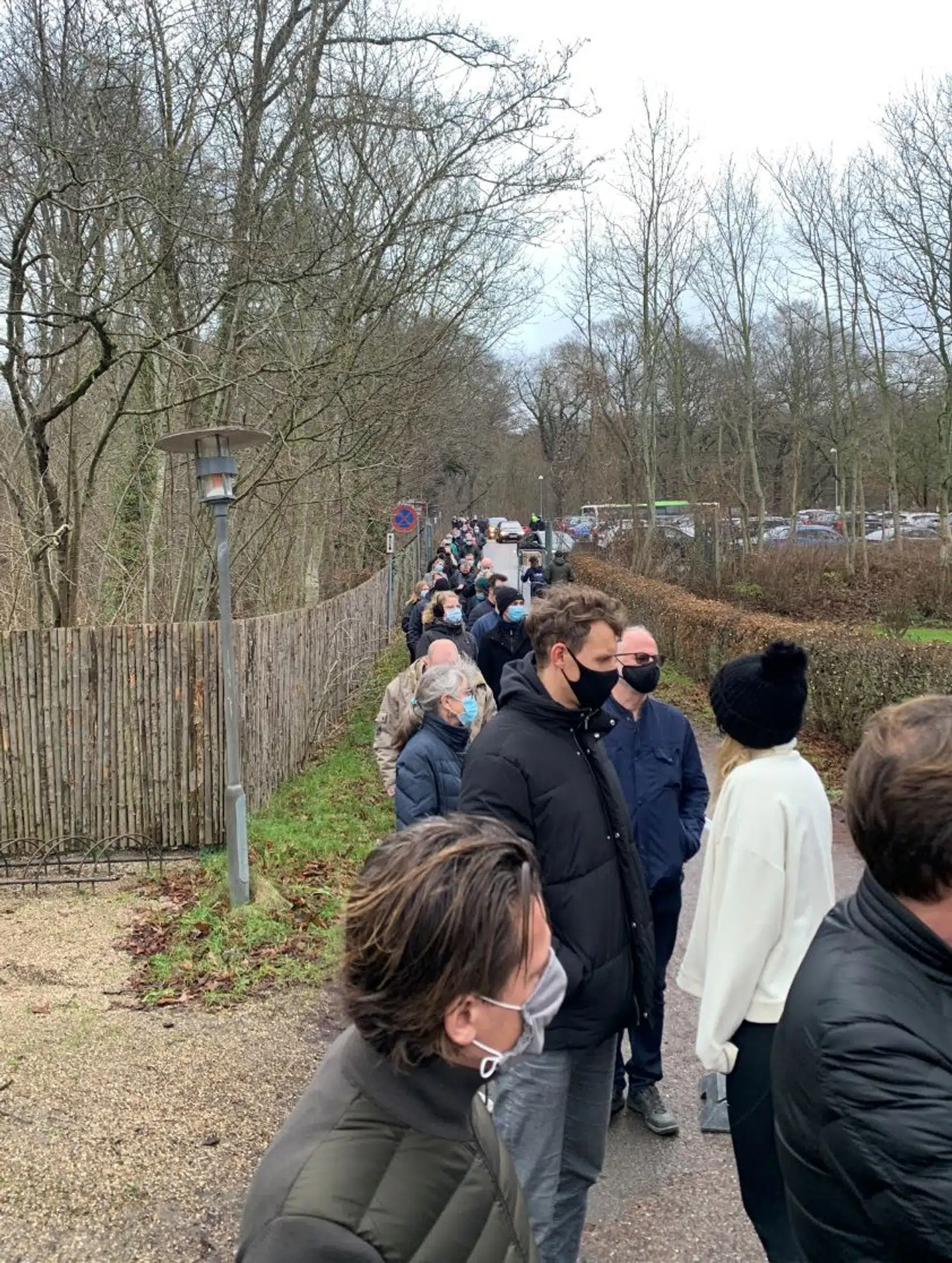 Køen strækker sig langt ud på den anden side af parkeringspladsen.