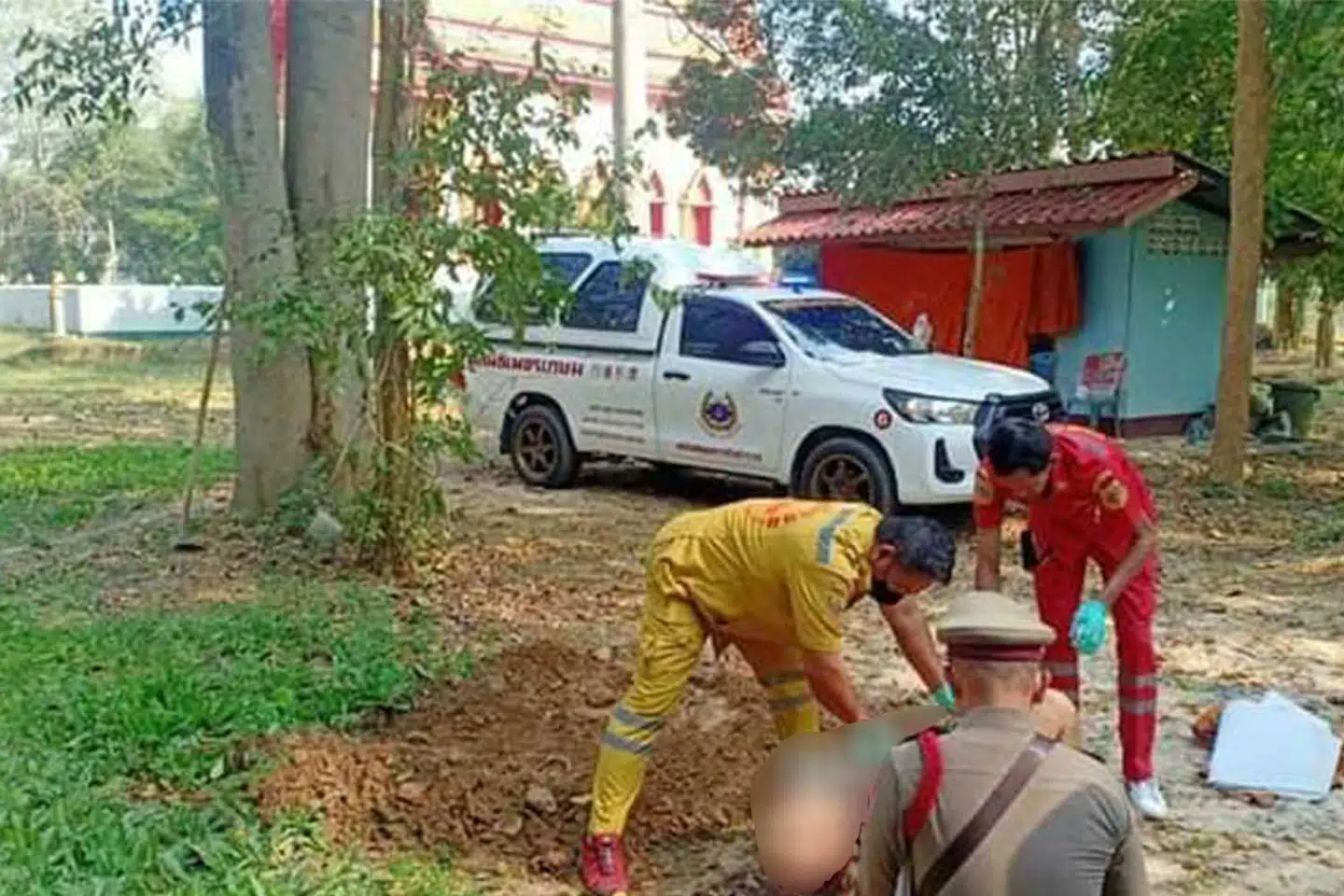 Politifolk er ved at bære den afdøde væk fra åstedet.