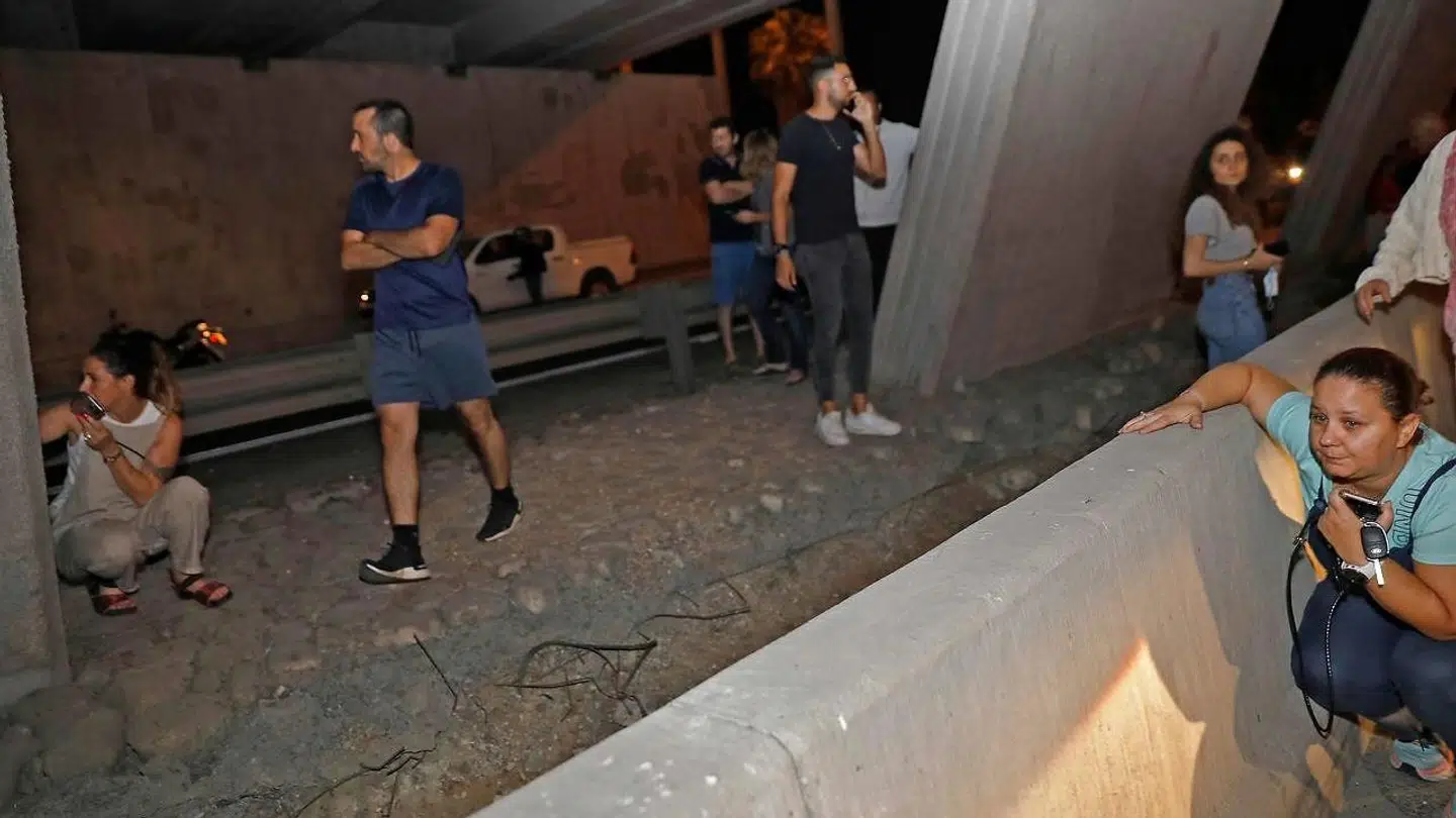 Folk søger dækning under en bro i den israelske by Tel Aviv efter raketter er blevet affyret fra Gaza. Billedet er fra den 11. maj.